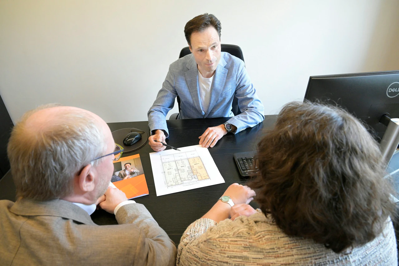 Consultant explains plans to a couple during a business meeting.