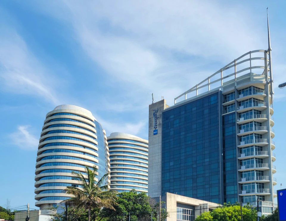 A tall building with a curved roof next to other buildings.
