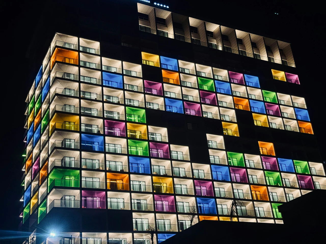 A multicolored building lit up at night.