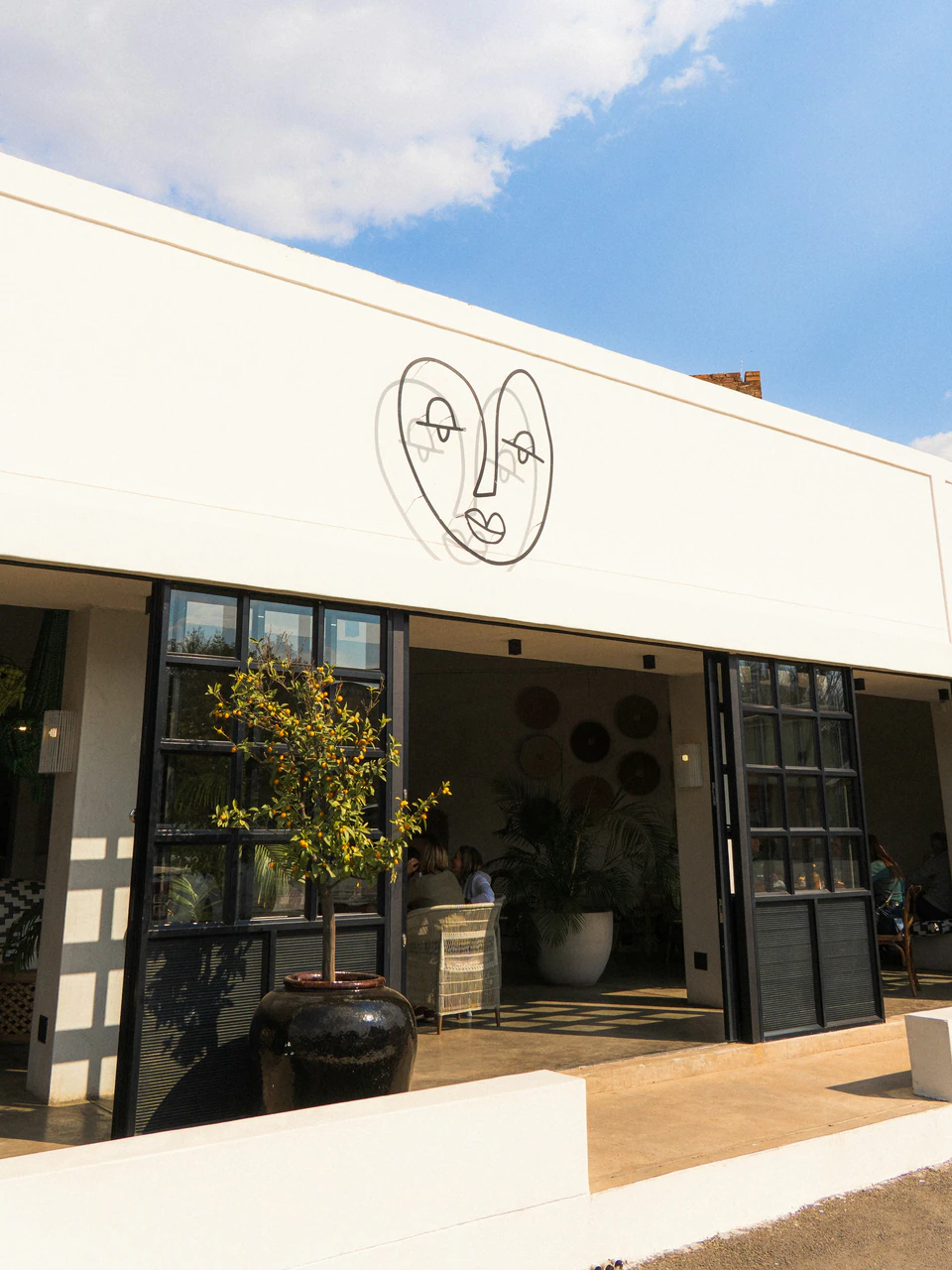 White cafe building with face mural.