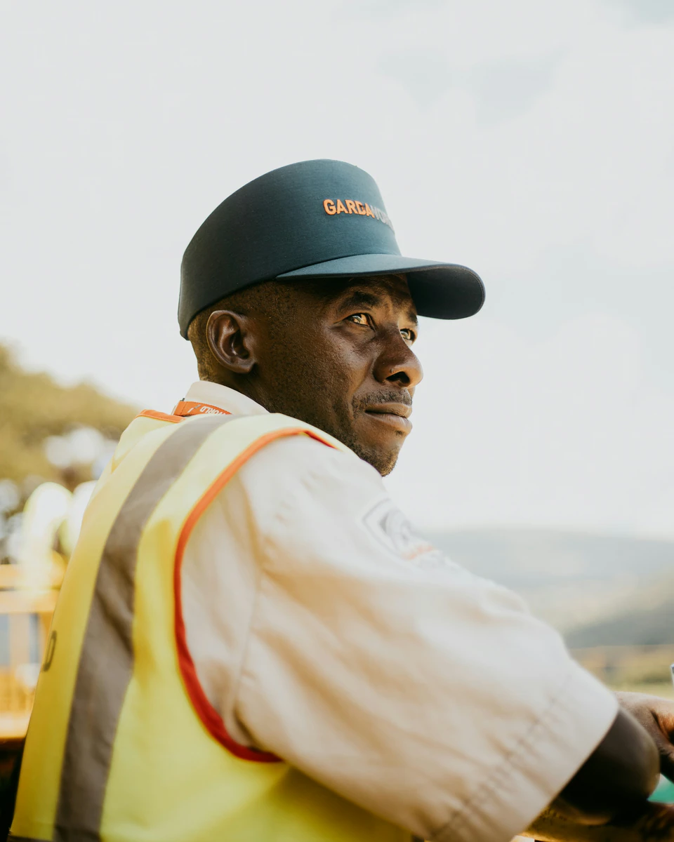 A man wearing a safety vest and a hat.