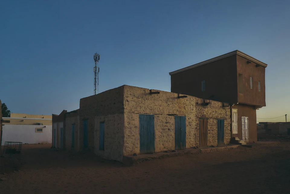 An old building with a windmill in the background.