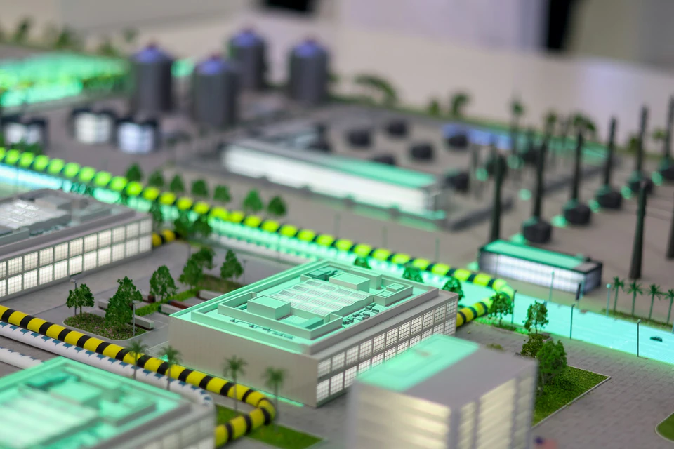 Miniature industrial complex with glowing lights.