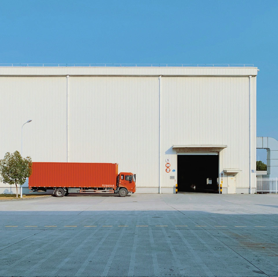 Red freight truck beside building.