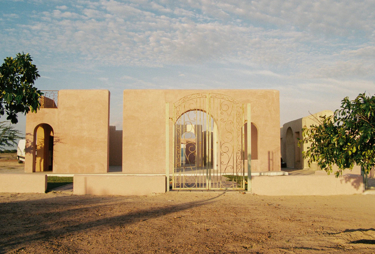 Arched building entrance in a dry desert like landscape.
